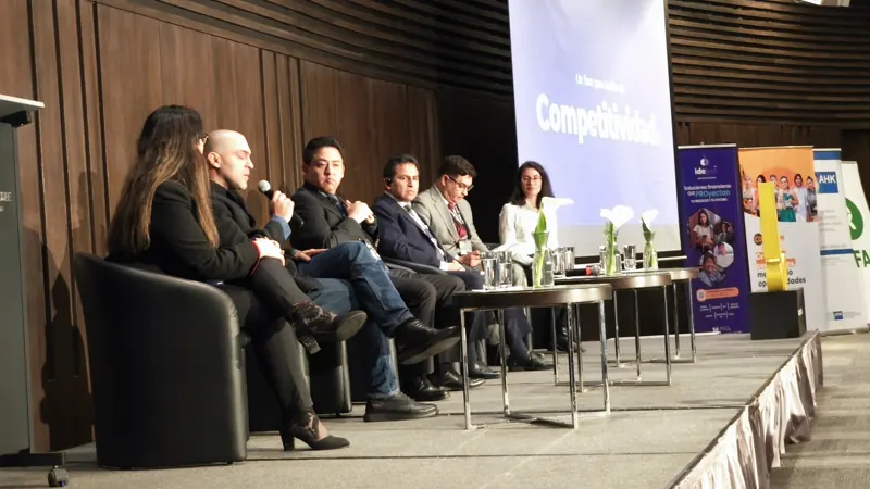 Panelistas conversan en el escenario